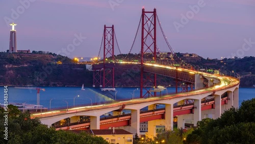 Time-lapse of Lisbon view from Miradouro do Bairro do Alvito tourist viewpoint of Tagus river, traffic on 25th of April Bridge and Christ the King statue in evening twilight. Lisbon, Portugal photo