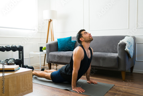 Relaxed man exercising with yoga in the living room