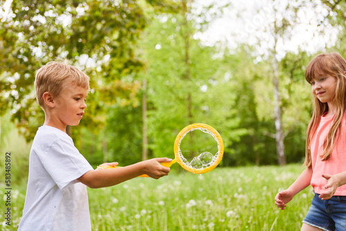 Boy with bubble wand by female friend