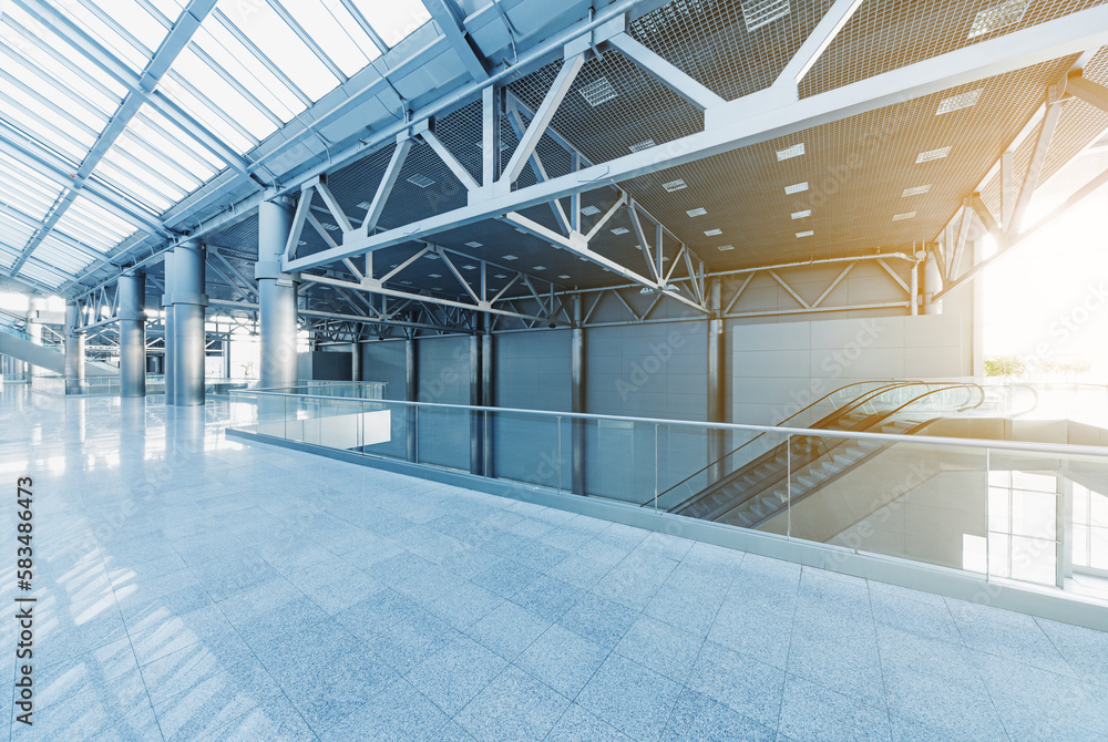 Escalators and corridors of modern office building or airport, glass walls and reflective floor, natural light and flare