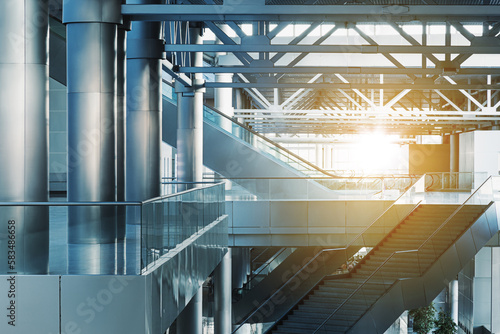 Obraz na płótnie Escalators and stairs in modern office building, airport or transport terminal, glass walls and reflective floor; natural light and flare w salonie