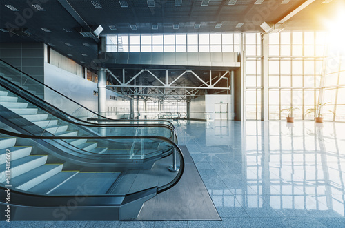 Obraz na płótnie Escalators and stairs in lobby of modern office building, airport or shopping mall, glass walls and reflective floor, natural light and flare w salonie