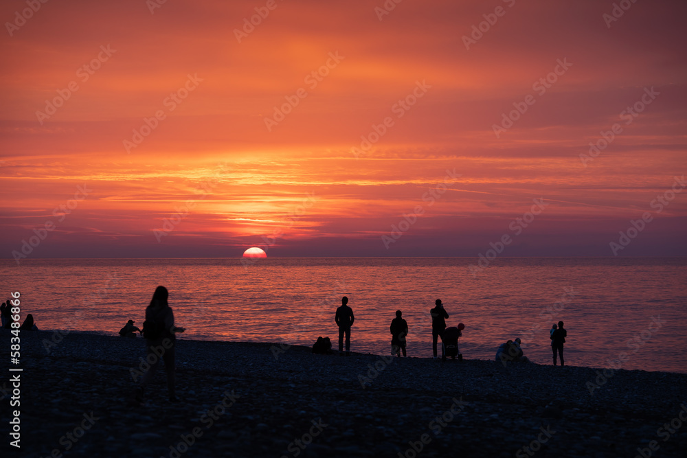 Silhouette of people on a beach enjoying the sunset