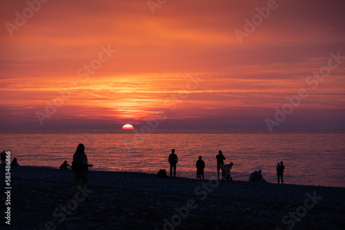 Silhouette of people on a beach enjoying the sunset