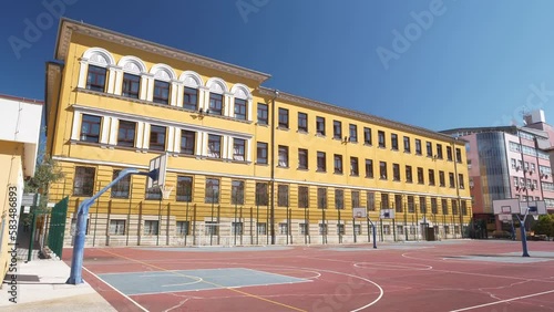 A view of the beautiful old school and the basketball court in front of it. photo