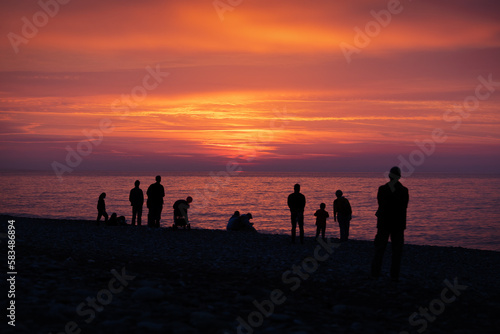 Silhouette of people on a beach enjoying the sunset