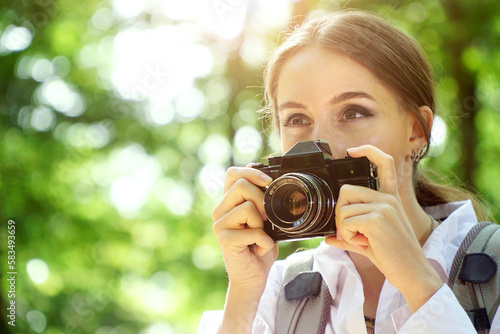 Woman in forest and taking pictures and photographs with a vintage analog film camera
