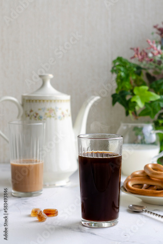 breakfast on the table: coffee pot, cup of coffee, bagels, sugar, beautifully served table