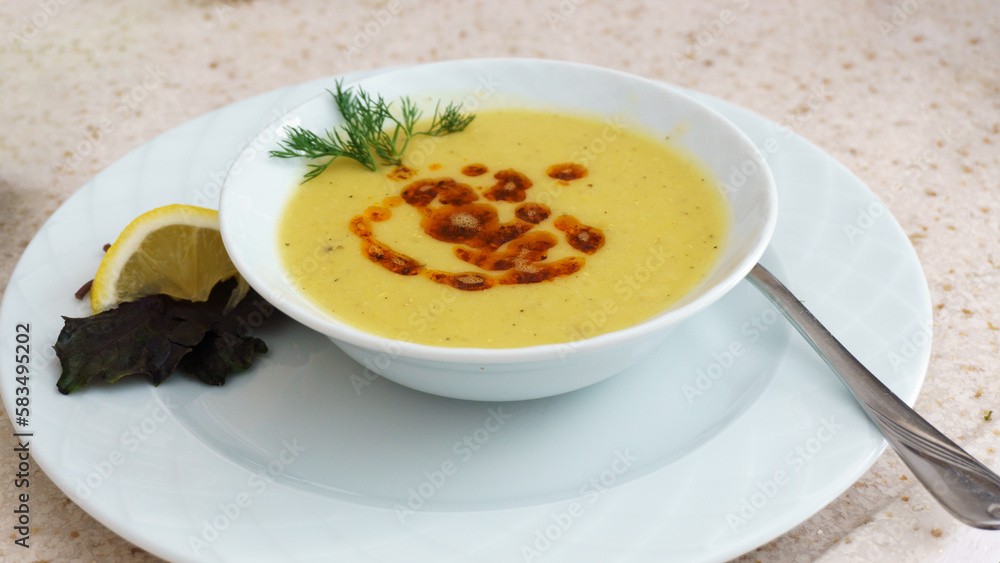Lentil Soup (Mercimek Çorbası in Turkish) plate on white table with bread and lemon. Lentil Soup (Mercimek Çorbası in Turkish) plate on white table with bread and lemon.