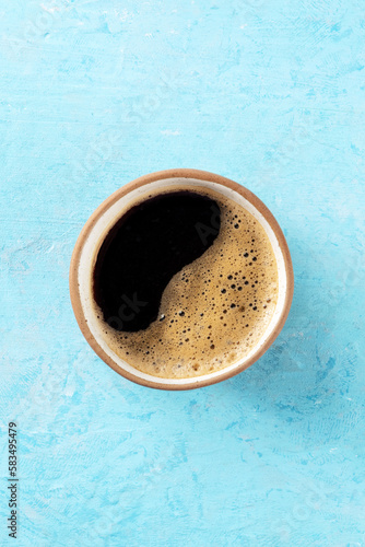 Coffee cup, top shot on a blue background with copy space, espresso drink