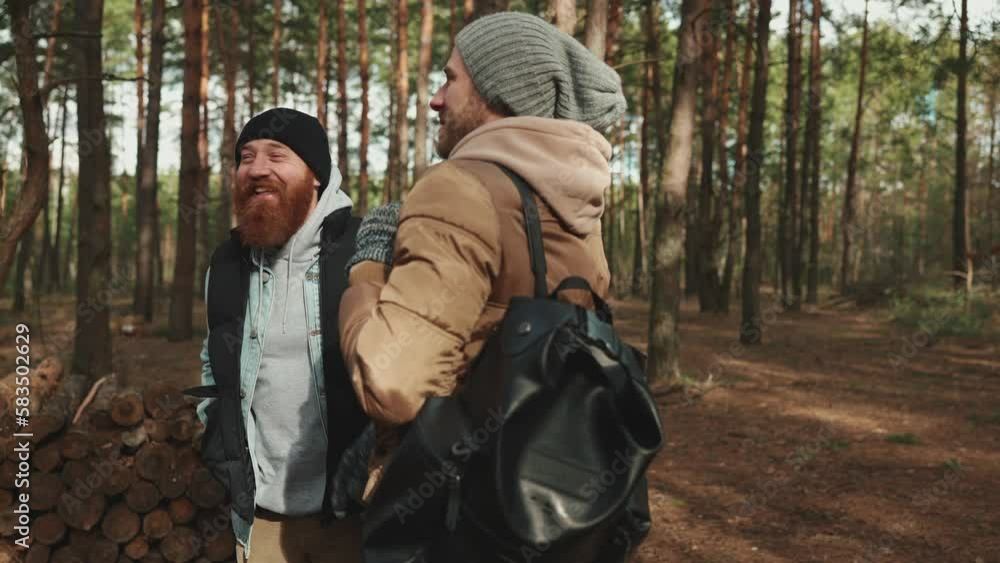 Two happy hiker friends talking while standing in the forest Two happy hiker friends talking while standing in the forest