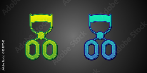 Green and blue Eyelash curler icon isolated on black background. Makeup tool sign. Vector