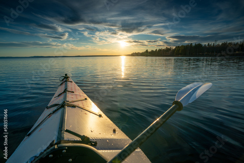 Silent serenity amidst a stunning sunset - kayaking through the breathtaking beauty of Scandinavia's tranquil lakes photo