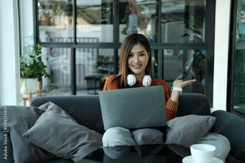 Young Asian woman wearing headphones to study online with her teacher, the girl is happy to learn. Young Asian woman wearing headphones to study online with her teacher, the girl is happy to learn.