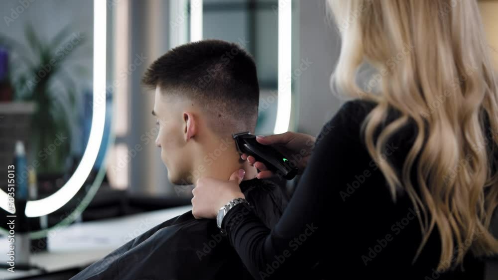 The process of a man's haircut from behind. Hairdresser stylist does a ...