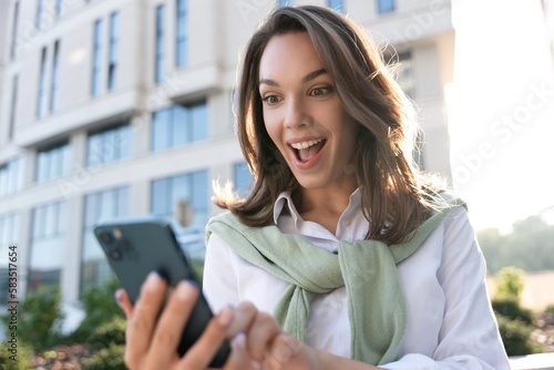 Young business woman wearing professional look smiling confident at the city using smartphone.