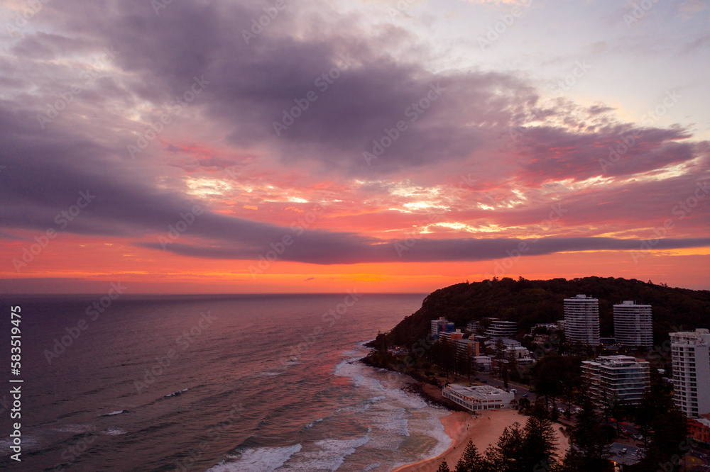 Obraz premium Sunlit pink clouds over Burleigh Headland and beach. Gold Coast, Australia