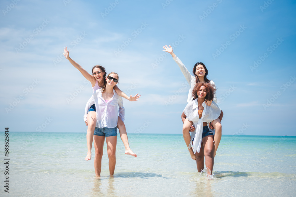 Group of diverse teenager friends enjoying on the beach, spending time together on summer, Young girl enjoy neck riding outdoor activity, Lifestyles on vacation concept. Group of diverse teenager friends enjoying on the beach, spending time together on summer, Young girl enjoy neck riding outdoor activity, Lifestyles on vacation concept.