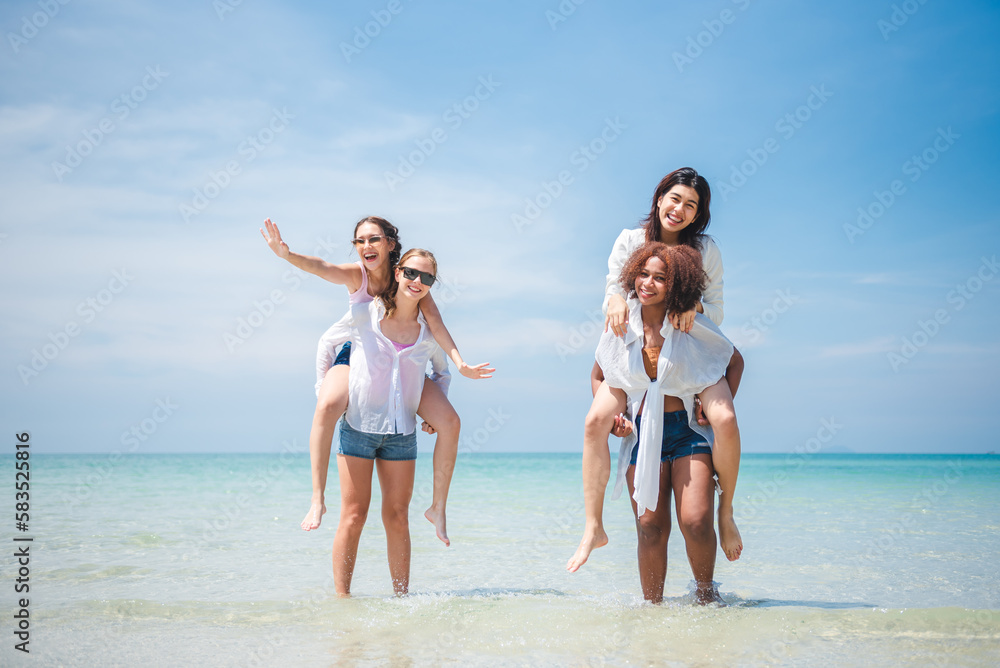Group of diverse teenager friends enjoying on the beach, spending time together on summer, Young girl enjoy neck riding outdoor activity, Lifestyles on vacation concept. Group of diverse teenager friends enjoying on the beach, spending time together on summer, Young girl enjoy neck riding outdoor activity, Lifestyles on vacation concept.