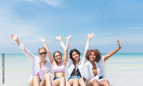 Group of diverse teenager friends sitting on the beach, spending time together on summer, Young girl enjoying with outdoor activity, Lifestyles on vacation concept.