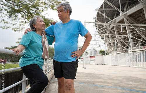 Happy and smile couples elderly asian standing on stairs for rest after workout, jogging on morning, senior exercise outdoor for good healthy. Concept of healthcare and active lifestyle for healthy