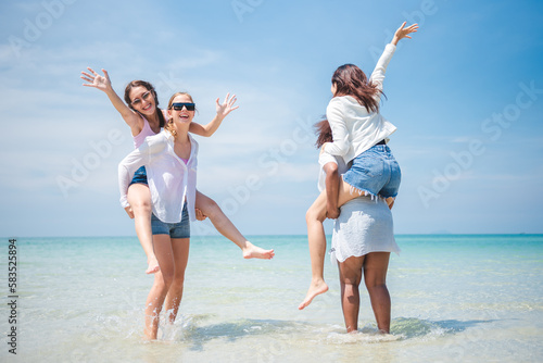 Group of diverse teenager friends enjoying on the beach, spending time together on summer, Young girl enjoy neck riding outdoor activity, Lifestyles on vacation concept.
