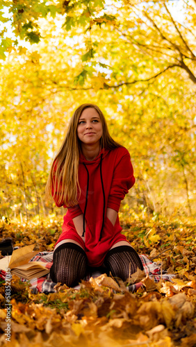 Incredible stunning girl in a red dress. The background is fantastic autumn. Artistic photography.