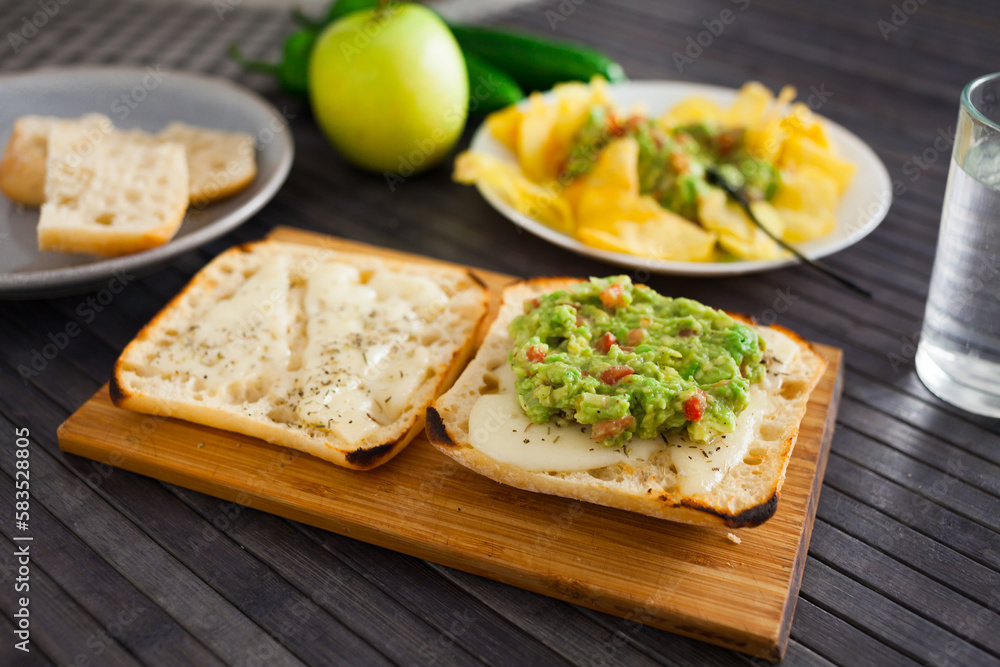 toasted slices of square bread with warm cheese and homemade guacamole on plate for healthy breakfast toasted slices of square bread with warm cheese and homemade guacamole on plate for healthy breakfast