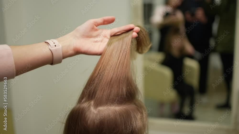A woman combs a little girl's hair with a comb A woman combs a little girl's hair with a comb