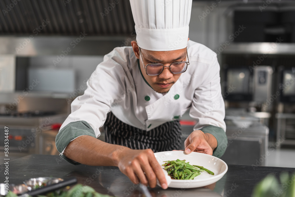 Asia teenager chef prepare food on dish at kitchen Asia teenager chef prepare food on dish at kitchen