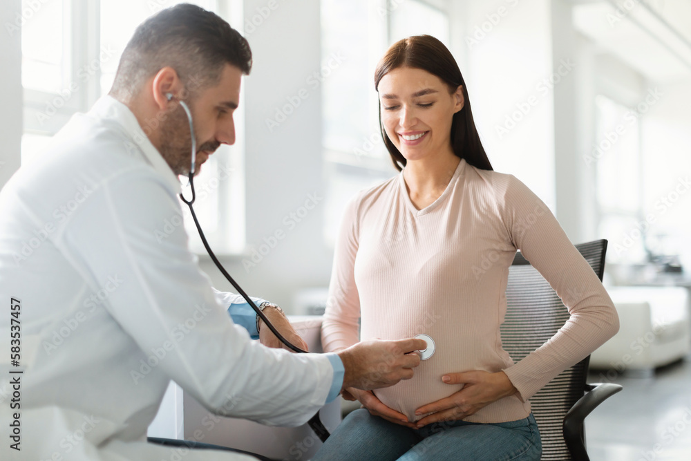 Obraz premium Gynecology consultation. Happy young pregnant woman visiting gynaecologist in maternity clinic, doing medical check-up