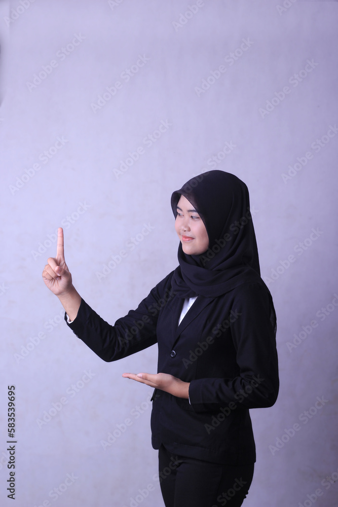 A woman in a black hijab points to the right. advertising concept A woman in a black hijab points to the right. advertising concept
