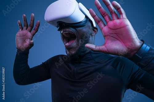 Shocked young black man screaming while experiencing virtual reality