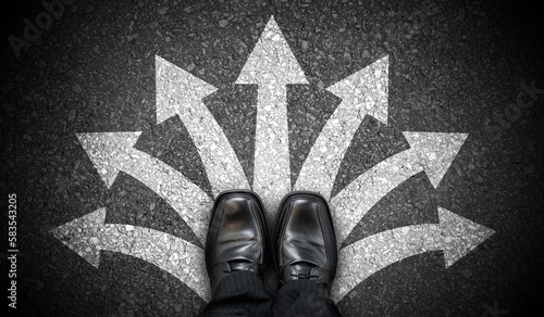 Fotografie Black business shoes and many chalky arrows on asphalt - decision concept
