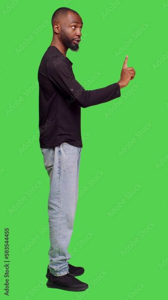 Vertical video: Profile of confident man expressing denial and saying no, doing negative gesture on camera. Displeased male model showing disappointment and disapproval, doing rejection symbol in Vertical video: Profile of confident man expressing denial and saying no, doing negative gesture on camera. Displeased male model showing disappointment and disapproval, doing rejection symbol in