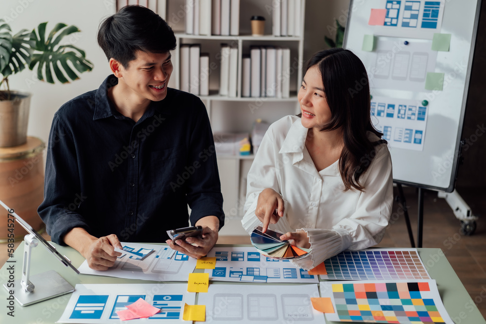 Fototapeta premium young husband and wife working at office by new project and happy