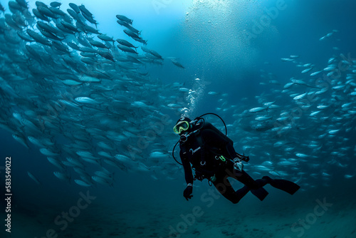 Scuba diver with a school of fish. Deep blue ocean, generative ai © Jezper