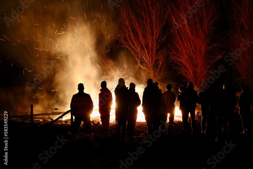 Buergbrennen festival in Luxembourg. Celebrating end of winter beginning of spring by burning mock castles. Black silhouettes of people admiring fire