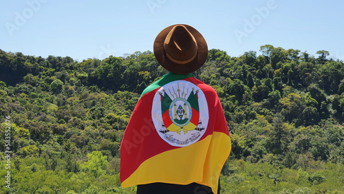 Fotografia, Obraz Young person holding the State Flag of Rio Grande do Sul - South Brazil