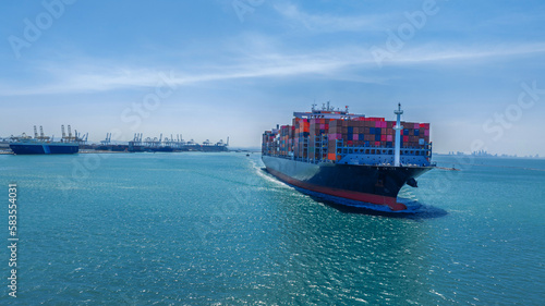 Aerial in front view of cargo ship carrying container and running for export goods from cargo yard port to custom ocean concept technology transportation , customs clearance.