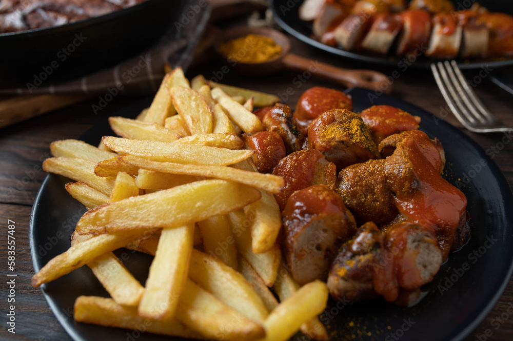 Homemade french fries with german curry sausage on rustic table Homemade french fries with german curry sausage on rustic table