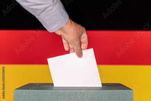Konstfotografi Man putting a ballot into a voting box against the background of the flag German