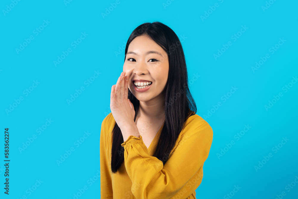 Cheerful chinese lady holding hand next to mouth, whisper something Cheerful chinese lady holding hand next to mouth, whisper something