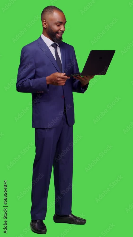 Vertical video: Side view of african american man attending videocall meeting on pc, using laptop to talk on remote teleconference chat. Young business manager in suit talking to people on Vertical video: Side view of african american man attending videocall meeting on pc, using laptop to talk on remote teleconference chat. Young business manager in suit talking to people on