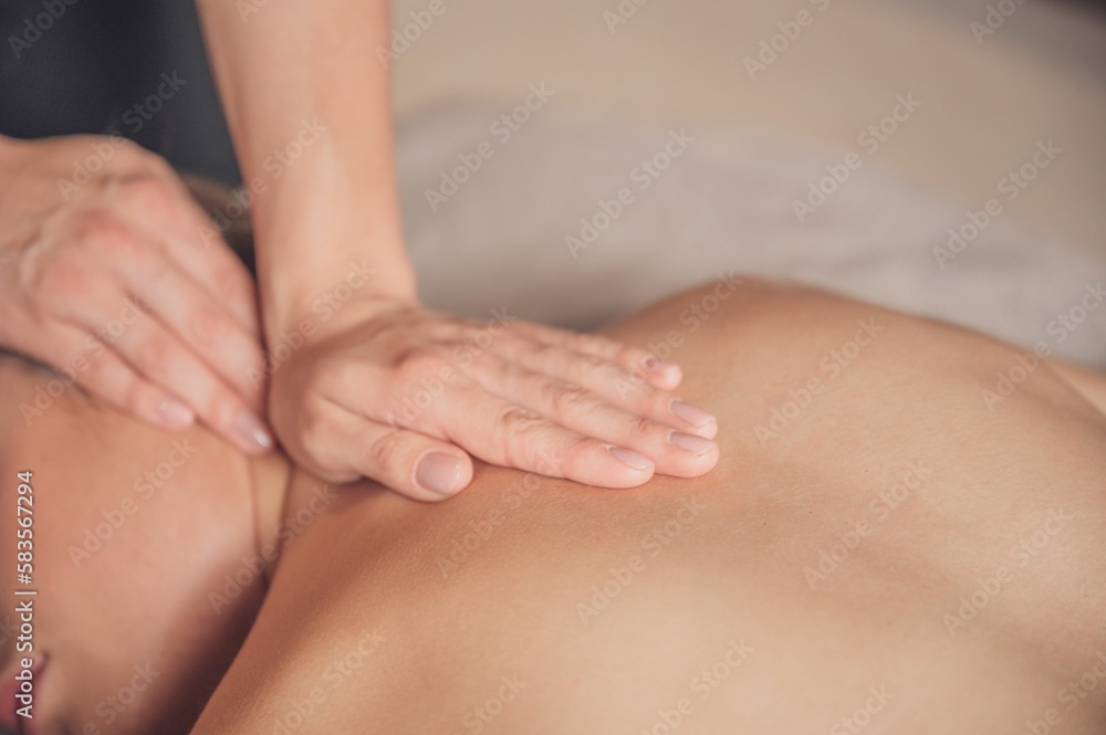 Closeup shot of the masseur's hands massaging the woman's back. Closeup shot of the masseur's hands massaging the woman's back.