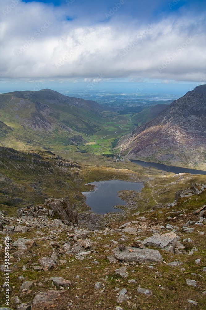 Vertical aerial view of the Ogwen Valley in between mountains, in Snowdon in Wales, on a cloudy day