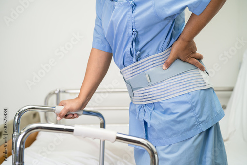 Asian lady patient use walker in hospital to support walking.