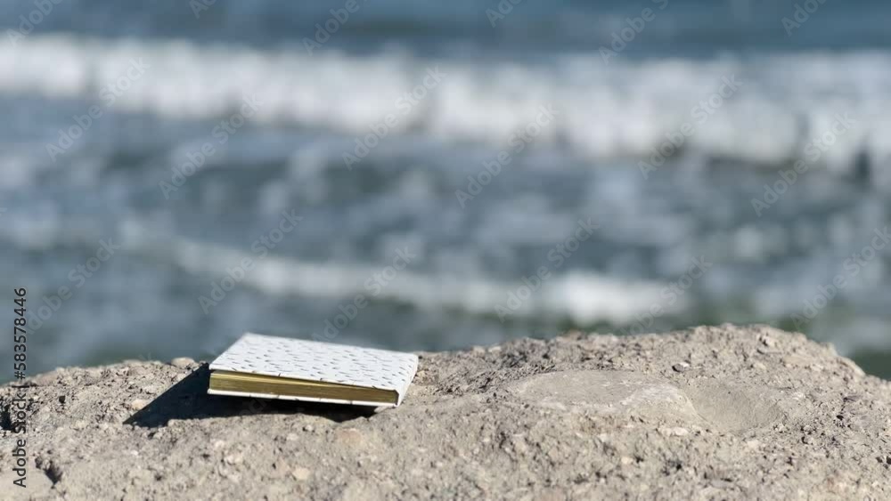 Closed Book on a beach, on background of sea waves Closed Book on a beach, on background of sea waves