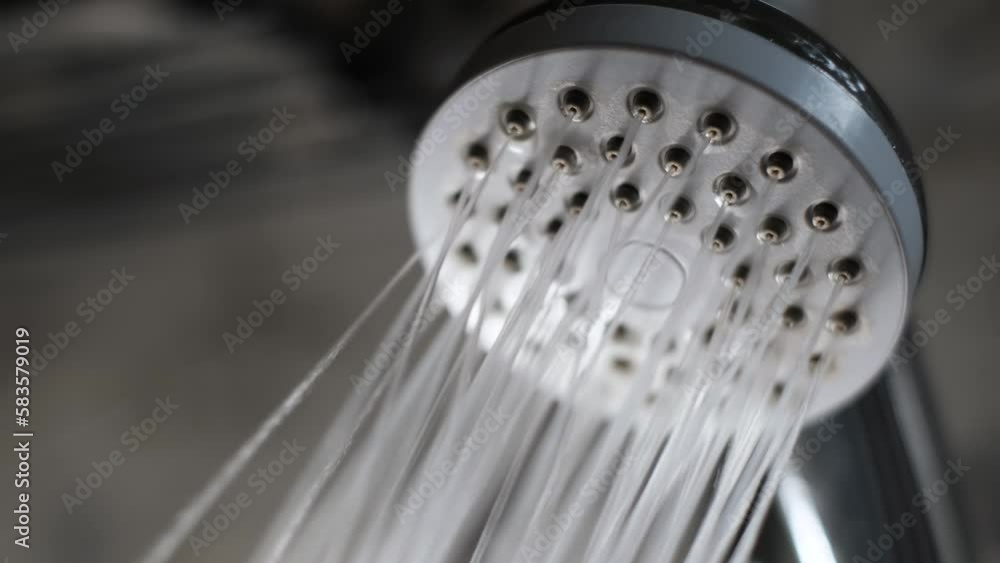 Water flows from the shower sprinkler in a powerful stream, close up Water flows from the shower sprinkler in a powerful stream, close up