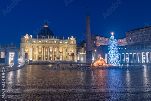 St. Peter Basilica with Nativity scene and Christmas tree at Christmas time in Vatican at night.